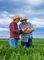 Two farmers review data standing in green field