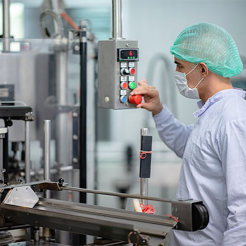 Manufacturing plant worker checking on process machine