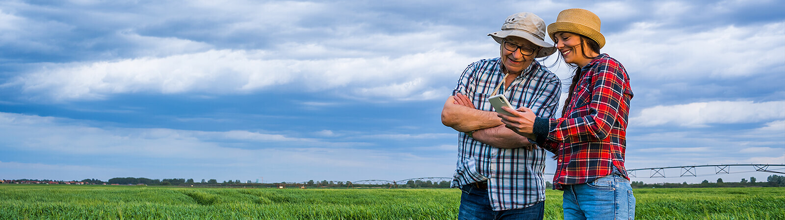 Two farmers in green field review crop management